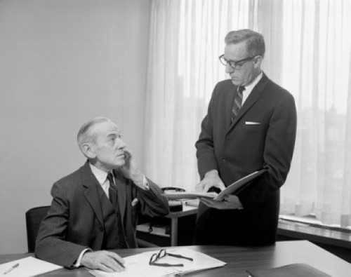 Two businessmen talking to each other in an office Poster Print - Item # VARSAL2559253