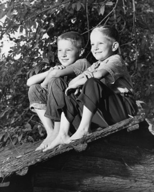Low angle view of two boys sitting on a thatched roof Poster Print - Item # VARSAL25516240