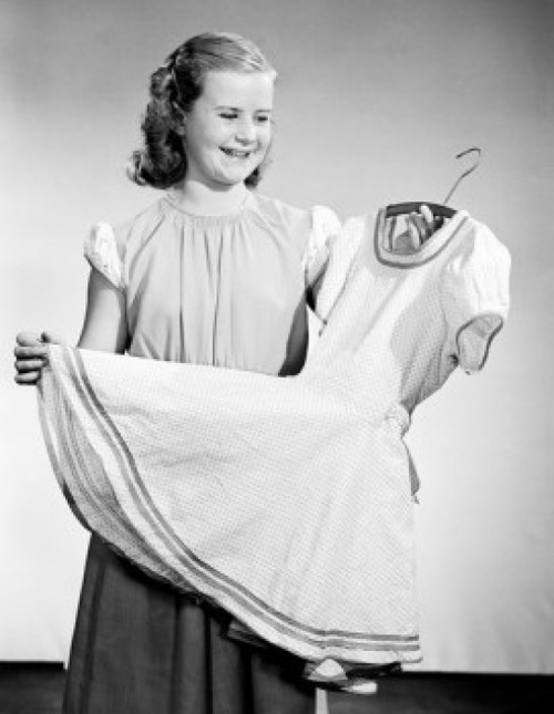 Studio shot of smiling girl holding new dress on hanger Poster Print - Item # VARSAL2555090