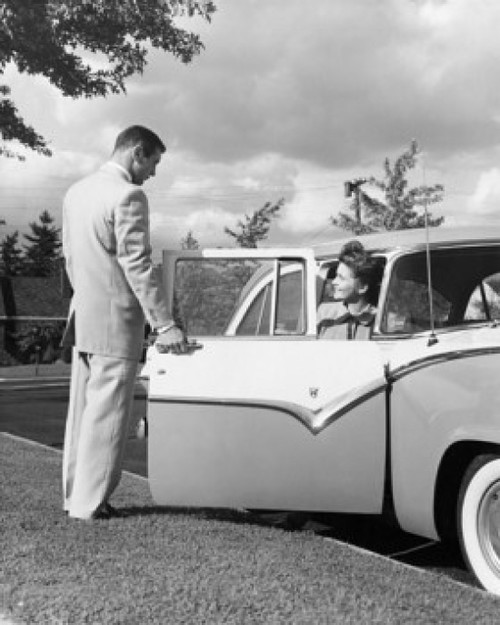 Young man opening the door of a car for a teenage girl Poster Print - Item # VARSAL2557542