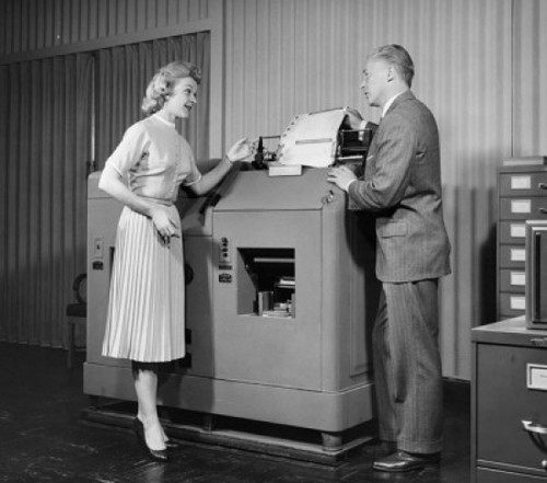 Businessman working on tabulating and accounting system and talking to businesswoman Poster Print - Item # VARSAL2551350