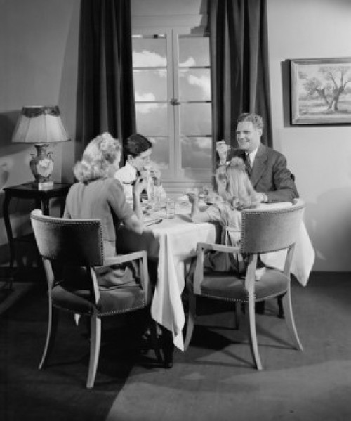 Parents with kids eating dinner at home Poster Print