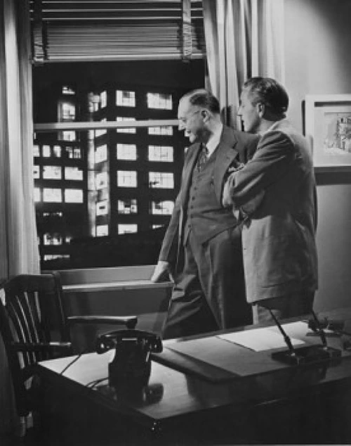 Two businessmen in office looking through window  1950s Poster Print