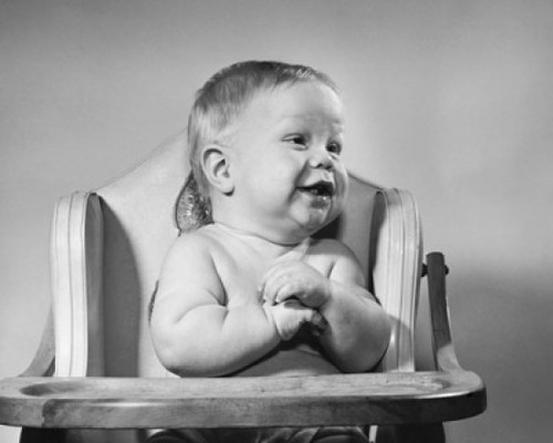 Baby sitting in a high chair and smiling Poster Print - Item # VARSAL2559711