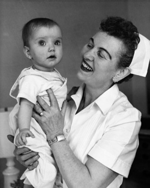 Close-up of a female nurse carrying a baby and smiling Poster Print - Item # VARSAL25533897 Close-up of a female nurse carrying a baby and smiling Poster Print - Item # VARSAL25533897