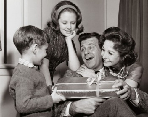 Close-up of a mature couple giving a birthday present to their son and their daughter standing beside them Poster Print - Item # VARSAL2552131