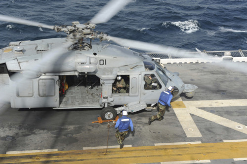Atlantic Ocean, November 4, 2013 - Air department personnel remove chock and chains from an H-60 Sea Hawk helicopter before take off from the multipurpose amphibious assault ship USS Bataan Poster Print - Item # VARPSTSTK108091M