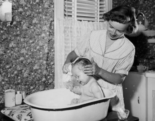 Young woman washing her son in a bathtub Poster Print