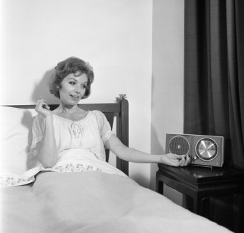 Portrait of mid adult woman reclining in bed and listening to the radio Poster Print - Item # VARSAL255420777