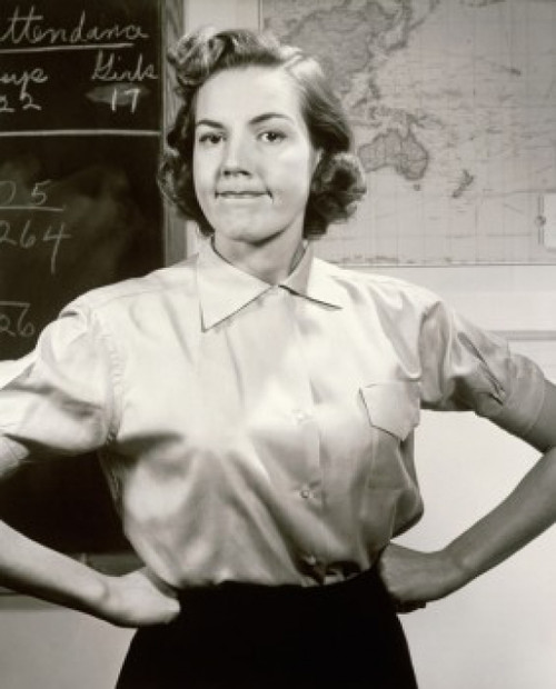 Portrait of a female teacher with arms akimbo in a classroom Poster Print - Item # VARSAL25517630
