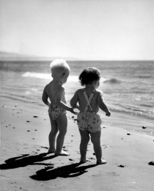 Pair of children wearing swimming costumes on beach  watching surf Poster Print - Item # VARSAL25516716