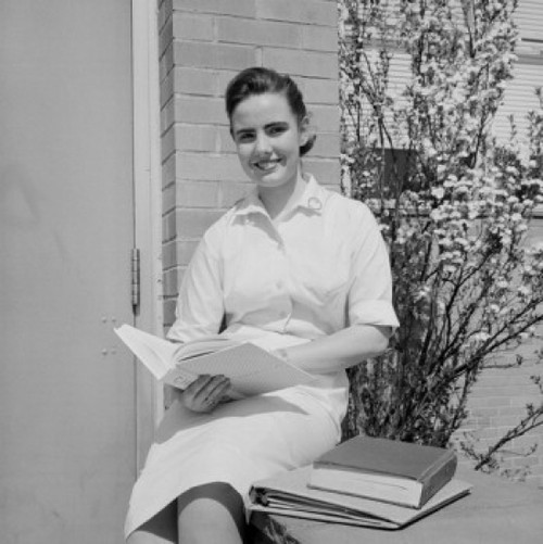 Portrait of teenage girl sitting and holding book Poster Print - Item # VARSAL255422149