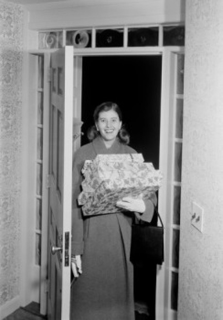Woman carrying Christmas presents in doorway Poster Print - Item # VARSAL255422276