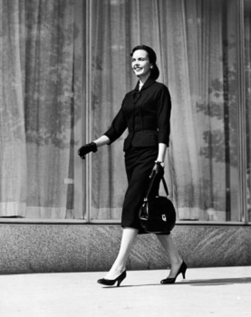 Young woman walking on a sidewalk holding a hand bag Poster Print - Item # VARSAL25515560
