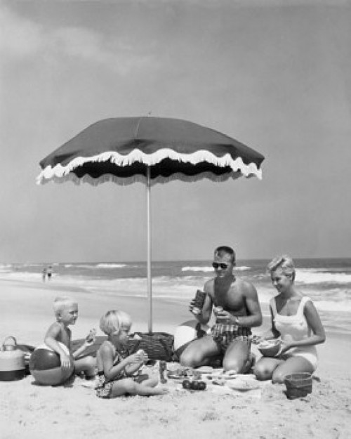 Mid adult couple with two children at picnic on beach Poster Print - Item # VARSAL2553142B
