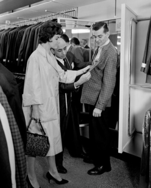 Woman assisting man trying on suit in shop Poster Print - Item # VARSAL255417872