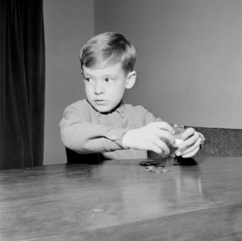 Young boy putting coins in piggybank Poster Print - Item # VARSAL255421999