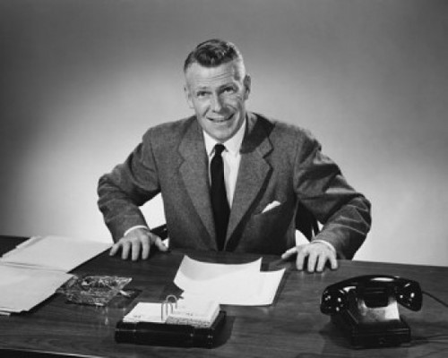 Businessman sitting at a desk and smiling in an office Poster Print - Item # VARSAL25548315B