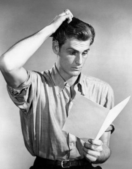 Young man reading a paper and scratching his head Poster Print - Item # VARSAL25536995