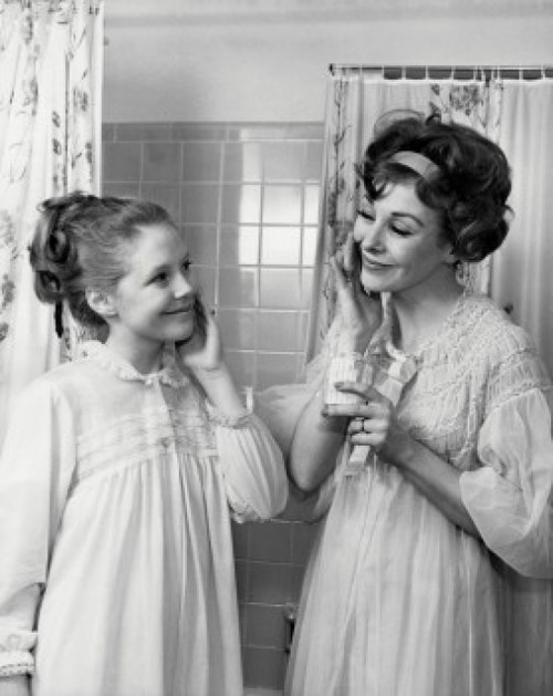 Mother and daughter applying moisturizer on their cheeks Poster Print - Item # VARSAL2551419