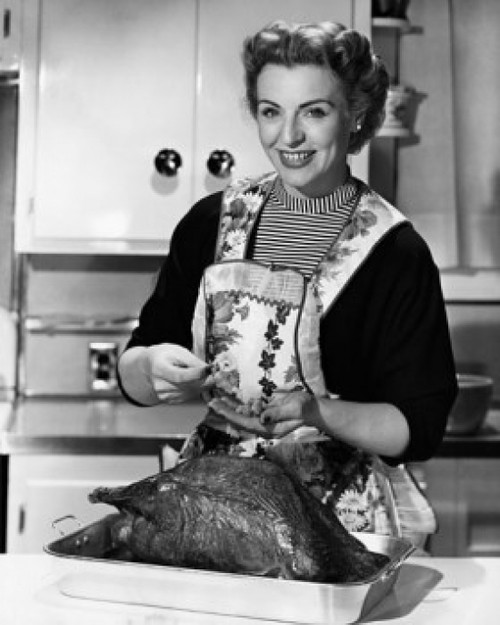 Portrait of a mature woman preparing a turkey in the kitchen Poster Print