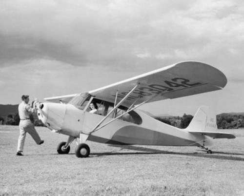 Man rotating the propeller of a private plane with a woman sitting in it Poster Print - Item # VARSAL25540650