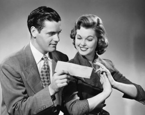 Close-up of a young man showing a check to a young woman Poster Print - Item # VARSAL2552939B