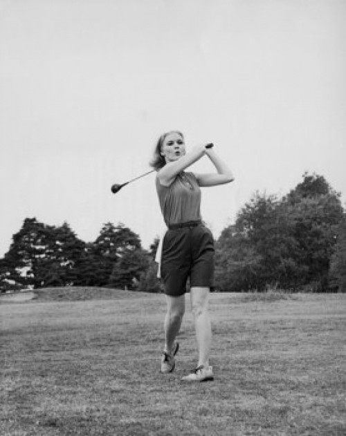 Young woman swinging golf club on golf course Poster Print - Item # VARSAL2554720