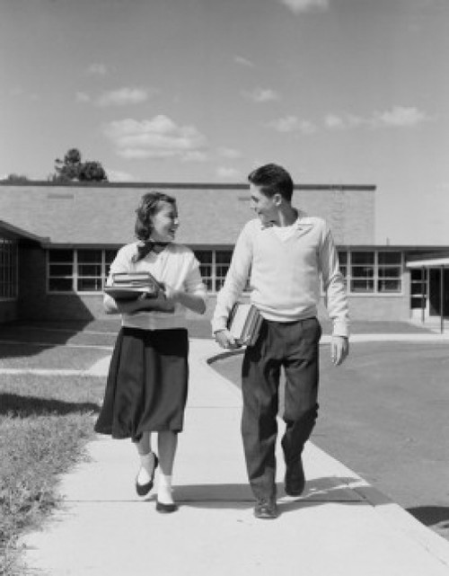 Teenage couple walking from school with books and smiling Poster Print - Item # VARSAL255422150