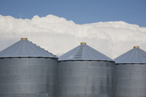 Three Grain Bins With Dramatic Thunder Storm Clouds In The Background And Blue Sky; Alberta, Canada PosterPrint - Item # VARDPI1998521