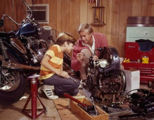 Mature man explaining an automobile engine to his son in a workshop Poster Print - Item # VARSAL3807460883