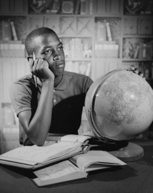 Teenage boy sitting at a table and studying Poster Print - Item # VARSAL25517563