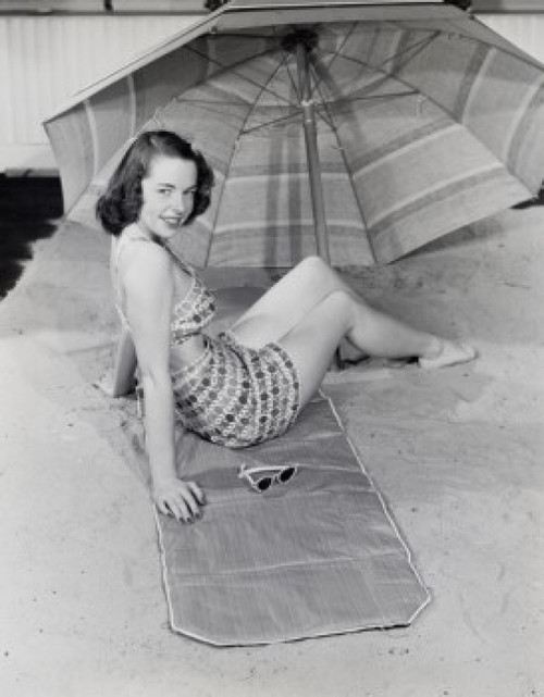Young woman sitting under beach umbrella Poster Print - Item # VARSAL255418744