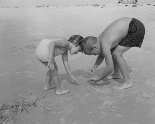 Boy and girl playing on beach Poster Print