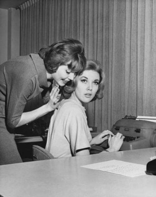 Side profile of a businesswoman whispering to another businesswoman in an office Poster Print - Item # VARSAL25528017