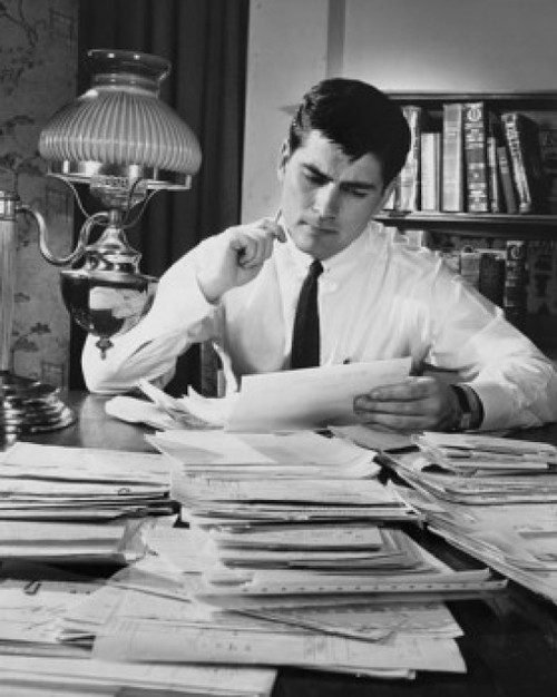 Businessman reading documents in an office Poster Print