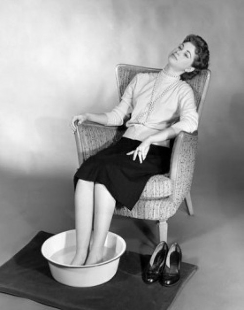 Young woman sitting with her feet soaked in a basin of water Poster Print - Item # VARSAL2552870