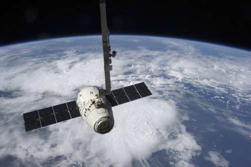 The SpaceX Dragon cargo craft prior to being released by the Canadarm2 robotic arm Poster Print
