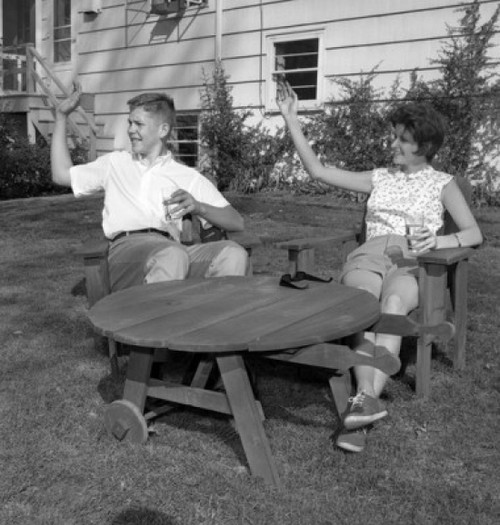 Young man and young woman sitting at outdoor table and waving Poster Print - Item # VARSAL255420829