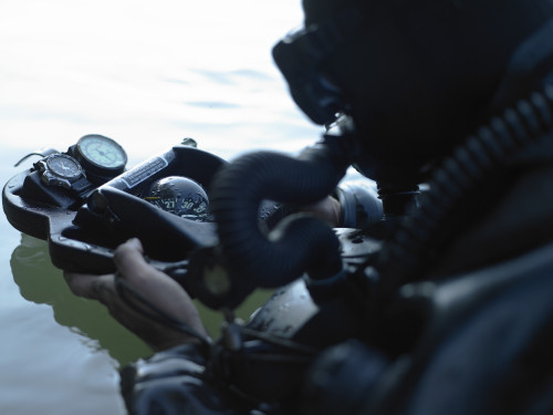 Special Forces combat diver takes a look at his compass to make sure he is on course to the target Poster Print - Item # VARPSTTWE300043M