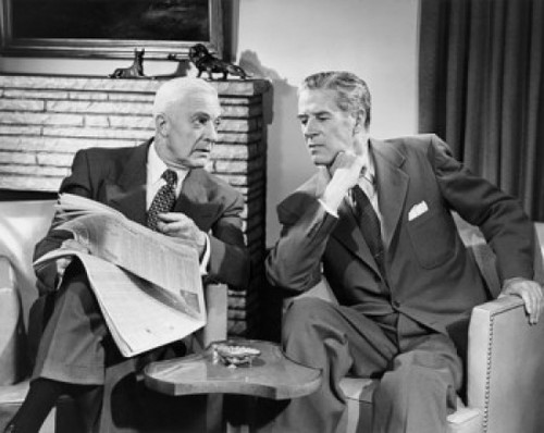 Two businessmen talking indoors Poster Print