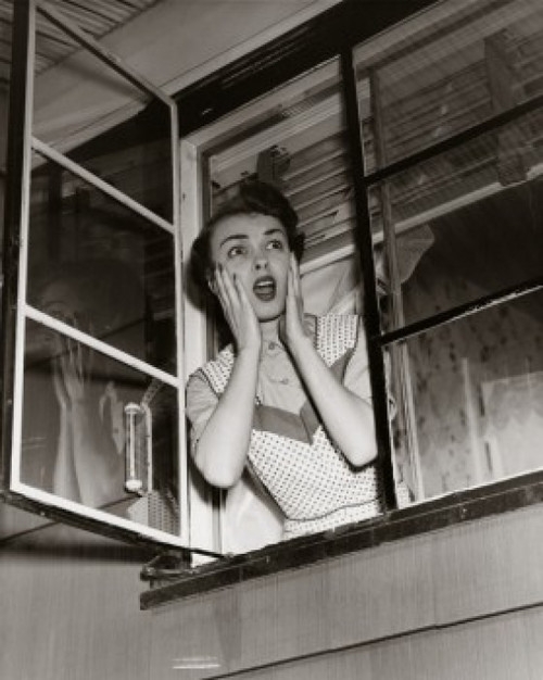 Mid adult woman looking through a window Poster Print