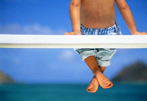 Hawaii, Legs And Feet Of Young Boy Sitting On A Bench By The Ocean PosterPrint - Item # VARDPI1995424