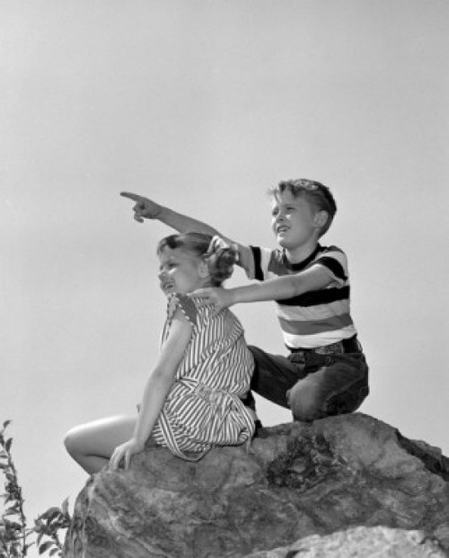 Boy and girl sitting on top of rock an looking at view Poster Print - Item # VARSAL25516259