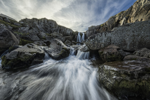 Stream flows over a waterfall and through the rocks along the eastern coast of Iceland; Iceland PosterPrint - Item # VARDPI12296399