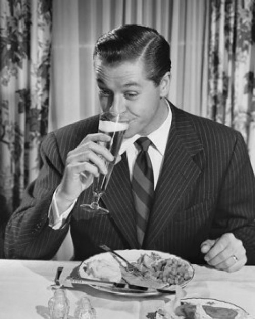 Mid adult man sitting at table drinking beer Poster Print - Item # VARSAL2554229B
