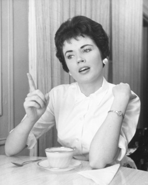 Young woman pointing and sitting with a tea cup Poster Print - Item # VARSAL25512654