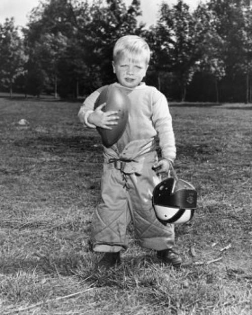Portrait of a boy holding a football and a helmet Poster Print - Item # VARSAL2557299