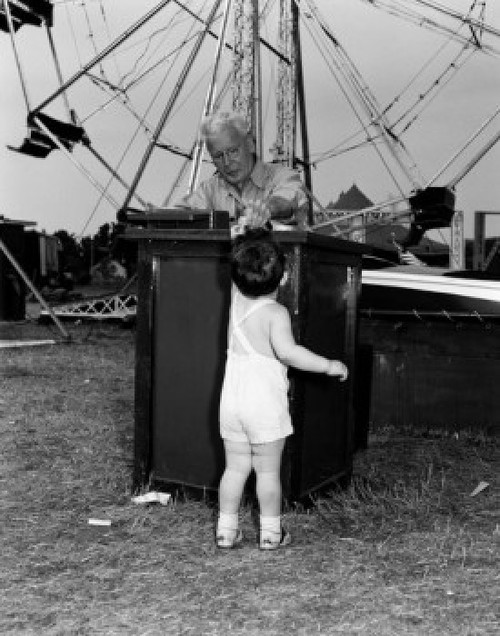 Boy paying for amusement park ride Poster Print