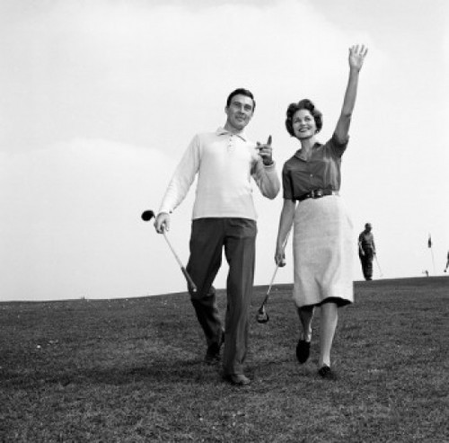 Mid adult man and mid-adult woman walking in golf course Poster Print - Item # VARSAL255417149